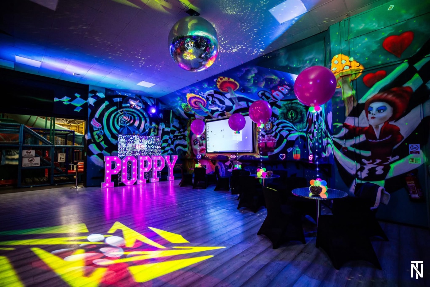The party room dressed with neon letters, balloons and a disco ball